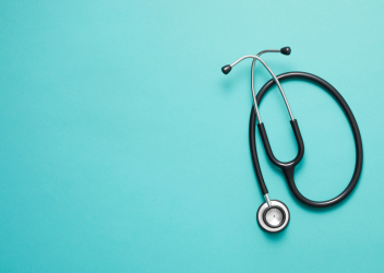 black stethoscope on light blue background